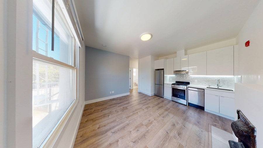 A kitchen with a stove top oven and a refrigerator.
